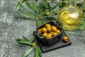 Branch with olives and a bottle of olive oil on dark background. top view. place for text Royalty Free Stock Photo