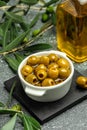 Branch with olives and a bottle of olive oil on dark background. top view. place for text Royalty Free Stock Photo