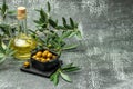 Branch with olives and a bottle of olive oil on dark background. top view. place for text Royalty Free Stock Photo