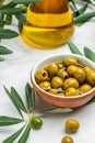 Branch with olives and a bottle of olive oil on light background. top view. place for text Royalty Free Stock Photo
