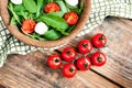 Branch of organic ripe cherry tomatoes and wooden bowl with vegetarian healthy salad with tomato, mozzarella cheese and arugula Royalty Free Stock Photo