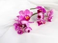 Branch of purple orchids on white fabric background. Purple orchid flowers on white fabric Royalty Free Stock Photo