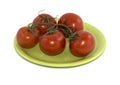 Branch of red tomatoes on a lime plate Royalty Free Stock Photo