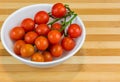 Branch of ripe cherry tomatoes on plate, top view in the wooden background Royalty Free Stock Photo