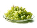 Branch of ripe green grape on a glass plate. Juicy lush grapes over white background, closeup shot Royalty Free Stock Photo