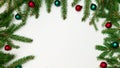 Branches of a Christmas tree border on one side on three sides with red and green balls on a white background Royalty Free Stock Photo