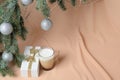 Branches of a Christmas tree, decorated with silver balls, a gift box, a glass mug with coffee and milk Royalty Free Stock Photo