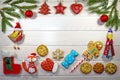 Branches of a Christmas tree, New Year`s decor, gingerbread and cookies on a light wooden background. Macro, horizontal photo.