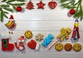Branches of a Christmas tree, New Year`s decor, gingerbread and cookies on a light wooden background. Macro, horizontal photo.