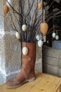 Branches with decorative eggs in a rubber boot