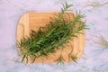 Branches of fresh rosemary on a wooden board. View from above.