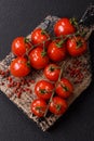 Branches of ripe red cherry tomatoes with salt and spices Royalty Free Stock Photo