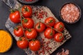 Branches of ripe red cherry tomatoes with salt and spices Royalty Free Stock Photo