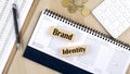 BRAND IDENTITY word written on wooden block on planner with coins, clipboard and a calculator Royalty Free Stock Photo
