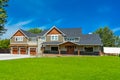 Brand new big farmer`s house with three garage door and blue sky background