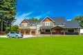 Brand new farmer`s house with a car on the driveway on blue sky background Royalty Free Stock Photo