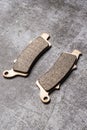 Brand new metallic motorcycle brake pads on a gray surface Royalty Free Stock Photo