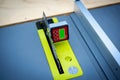 Brand-new table saw with digital level box inclinometer showing 0-degree angle attaches to steel blade and aluminum fence