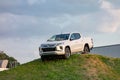 Brand new white Mitsubishi L200 pickup presented by dealership on an artificial hill to promote the automotive brand