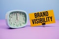 Brand Visibility text and alarm clock on blue and purple background Royalty Free Stock Photo