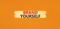 Brand yourself symbol. Concept words Brand yourself on beautiful wooden stick. Beautiful orange table orange background. Business Royalty Free Stock Photo