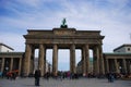 The Brandenburg Gate under a blue sky with some clouds in Berlin