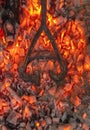 Branding iron for cattle over embers