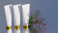 Branding and minimal presentation. Three cream bottles of white color with a golden cap. There are flowers nearby. 3D