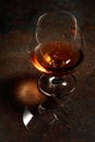 The drop of brandy falls into a broken glass Royalty Free Stock Photo