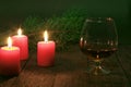 Brandy glass and candles on black background Royalty Free Stock Photo