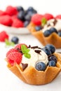 Brandy snaps baskets with soft cream cheese and berries on whit Royalty Free Stock Photo