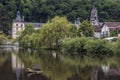 BRANTOME, FRANCE - MAY 27, 2019: The Benedictine abbey Saint-Pierre de Brantome and its bell tower along the river Dronne,