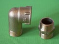 Brass adapter elbow with external-internal thread and brass nipple, used to connect pipes with threaded fittings of the same