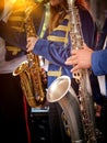 Vertical close-up images of a group of saxophonists in the foreground