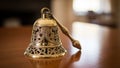 Brass bell with intricate openwork design sits on a polished wooden table. The craftsmanship Royalty Free Stock Photo