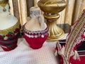 Brass bowls and jugs are covered with red fabric with handmade embroidery. Decorative crockery in the Middle Eastern