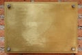 Brass or bronze metal plate on brick wall background Royalty Free Stock Photo