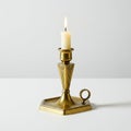 Brass candlestick with a lit white candle, featuring an octagonal base and a looped Royalty Free Stock Photo