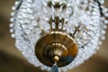 Brass chandelier with crystal chains hanging on ceiling