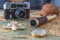 brass compass, a spyglass and a starfish lie on an old map against the background of a vintage film camera Royalty Free Stock Photo