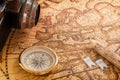 Brass compass, a wooden pencil and an old camera lie on an old vintage map