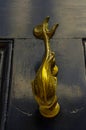 Brass fish knocker, knocker on black wooden door, decorative element, vintage Royalty Free Stock Photo