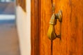 Brass hand knocker on old wooden door. Wooden carved door with rusted hand knocker. Royalty Free Stock Photo