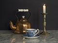 Brass Kettle and Candlelight and China Cup on Marble table Black Background Royalty Free Stock Photo