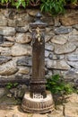 Brass Metal Fountain on an Old Marble Column in front of a Stone