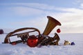 Brass musical wind instrument on snow and Christmas baubles