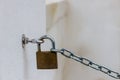Close-Up of a Padlock Securing a Chain to a Wall Hook Royalty Free Stock Photo