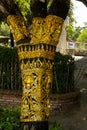 Brass plate carved in Thai style on a tree