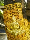 Brass plate carved in Thai style on a tree
