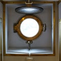 Brass porthole on an old military steam ship. Royalty Free Stock Photo